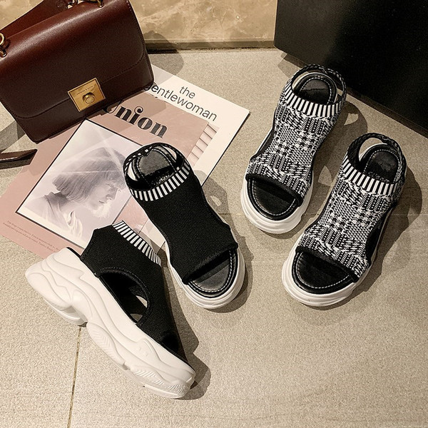 Modern női szandál két színben egy emelvényen