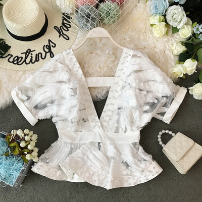 Modern női blúz mély nyakkivágással és gyöngyökkel, rövid ujjal