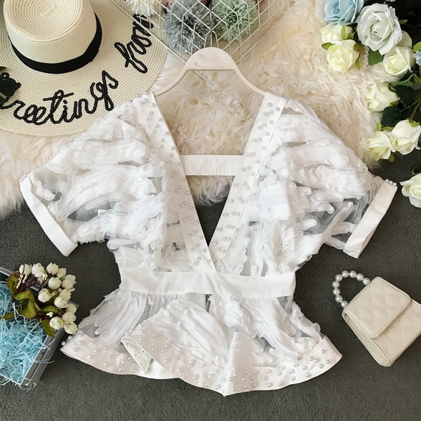 Modern női blúz mély nyakkivágással és gyöngyökkel, rövid ujjal