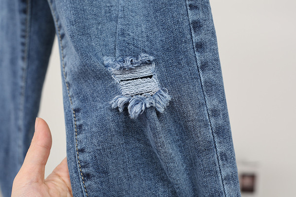 Modern női farmer magas derékkal, szakadt motívumokkal