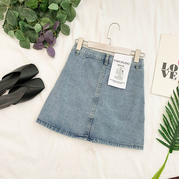 Női farmerszoknya kék és fekete gombokkal