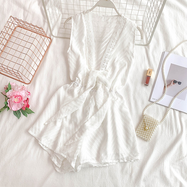 Modern női overall mély nyakkivágással és fekete-fehér nyakkendővel