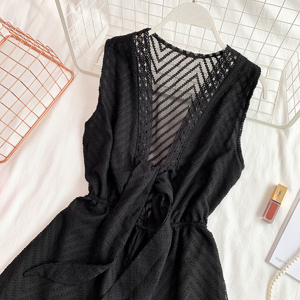 Modern női overall mély nyakkivágással és fekete-fehér nyakkendővel