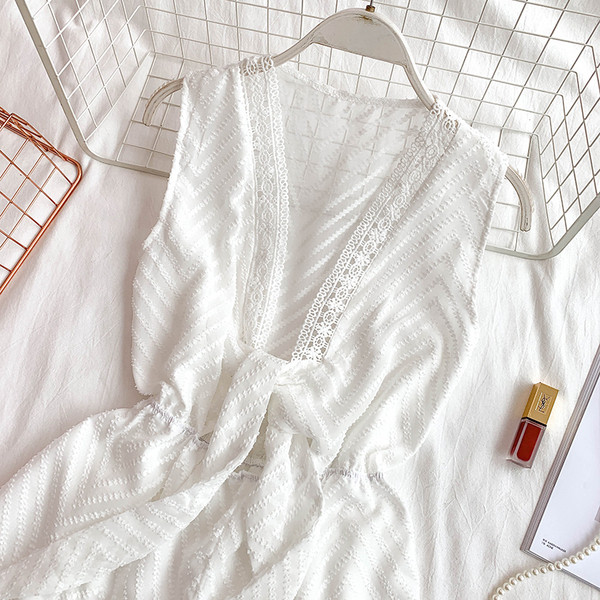 Modern női overall mély nyakkivágással és fekete-fehér nyakkendővel