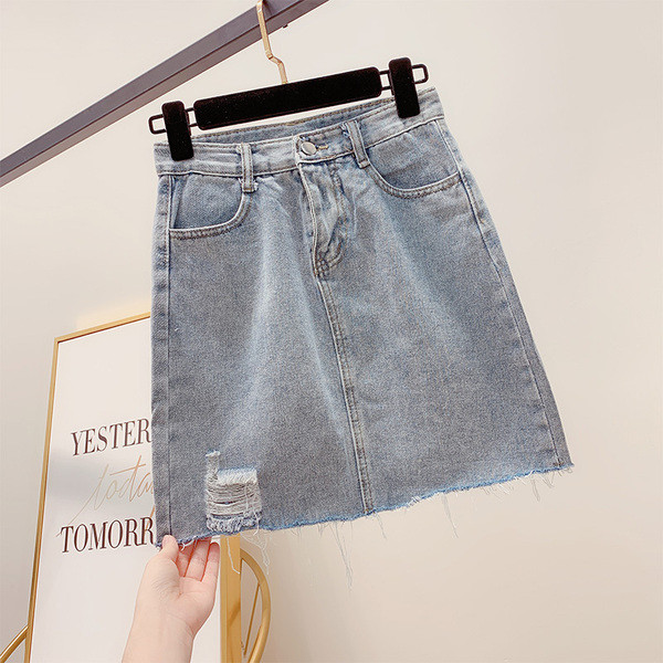 Modern női farmerszoknya szakadt motívumokkal