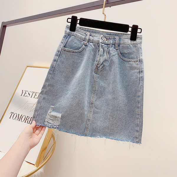 Modern női farmerszoknya szakadt motívumokkal