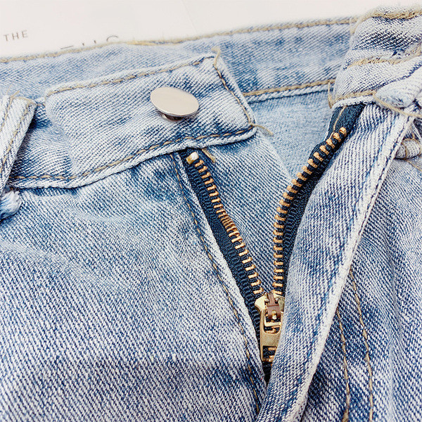 Modern női farmerszoknya szakadt motívumokkal