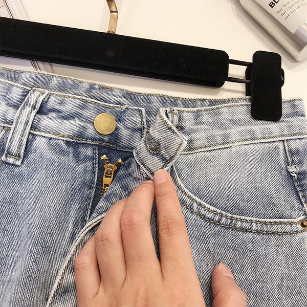 Női farmerszoknya szakadt motívumokkal, magas derékkal