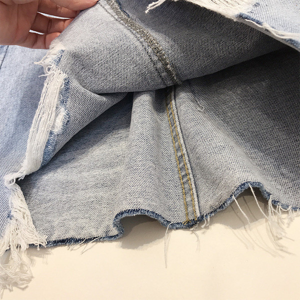 Női farmerszoknya szakadt motívumokkal, magas derékkal