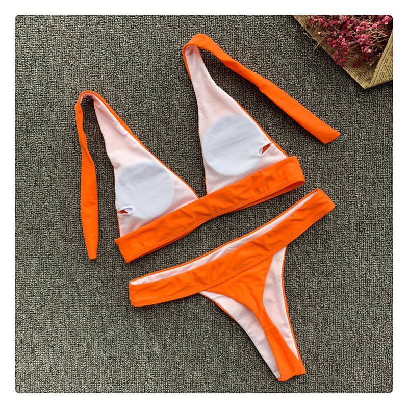 Costum de baie modern din două piese cu elemente metalice în roșu și portocaliu