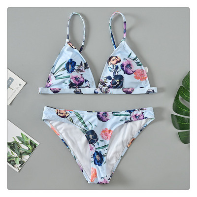 Costum de baie modern cu top triunghiular și motive florale în albastru