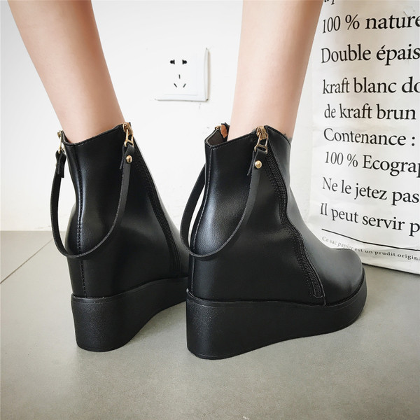 Κομψές κυρίες μπότες σε μια πλατφόρμα σε απλό σχέδιο και ελαφρώς κωνικό