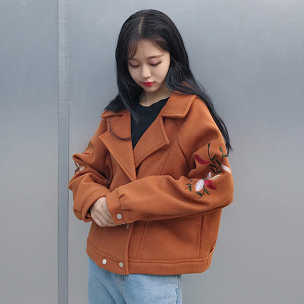 Σύντομη γυναικεία παλτό με κεντήματα στα μανίκια σε ένα ευρύ σχέδιο