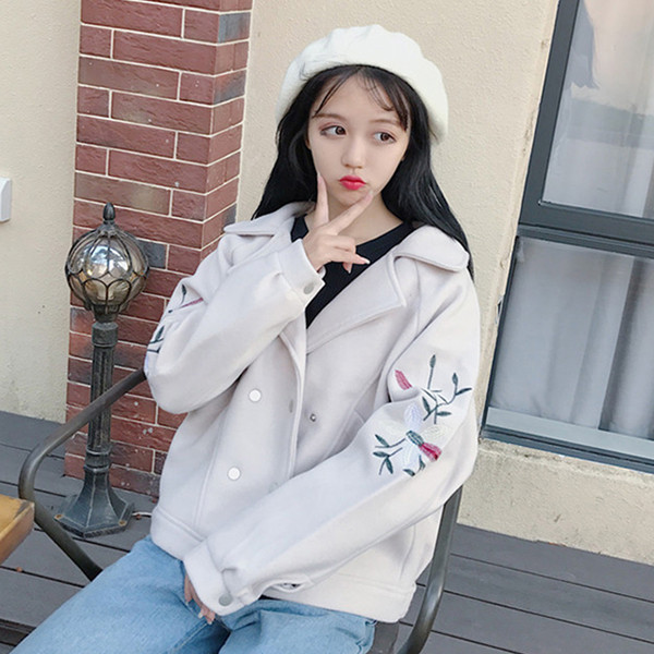 Σύντομη γυναικεία παλτό με κεντήματα στα μανίκια σε ένα ευρύ σχέδιο