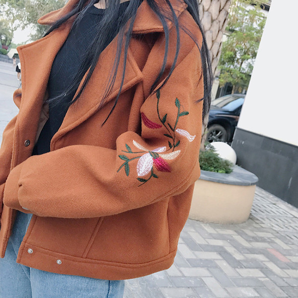 Σύντομη γυναικεία παλτό με κεντήματα στα μανίκια σε ένα ευρύ σχέδιο