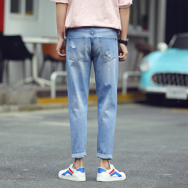 Τα μοντέρνα λεπτό τζιν των νέων ανδρών με ελαφρά μπαλώματα