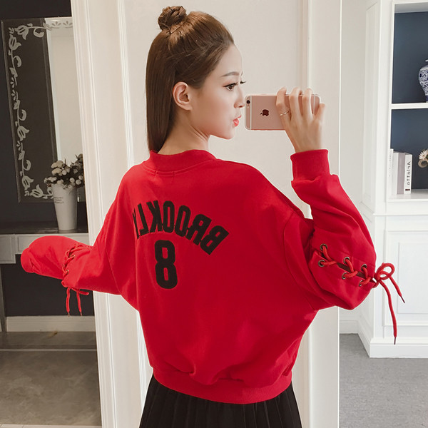 Αθλητικό πουλόβερ κυρίες με φερμουάρ, ενδιαφέρουσες συνδέσεις toe και μαύρο και κόκκινο χρώμα στο πίσω μέρος