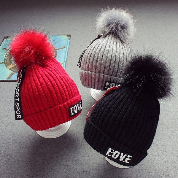 Стилна плетена детска шапка в няколко цвята с надписи и пухче