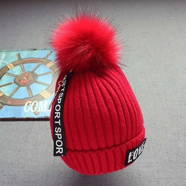 Стилна плетена детска шапка в няколко цвята с надписи и пухче