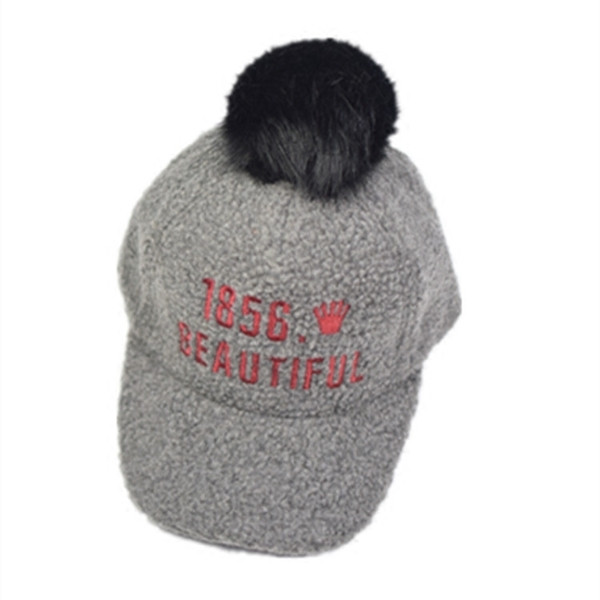 Вълнена детска шапка с козирка и пухче