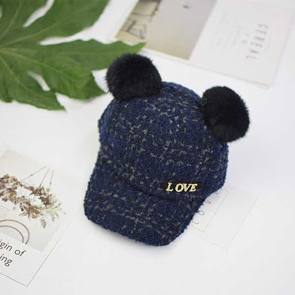 Вълнена детска шапка с козирка и пухчета,с  метален надпис