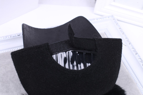 Дамска шапка с козирка и две пухчета в черен цвят