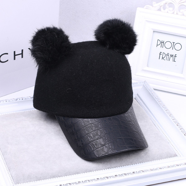 Дамска шапка с козирка и две пухчета в черен цвят