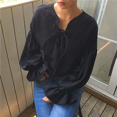 Κομψή γυναικεία πουκάμισα με ενδιαφέρουσες σταυρωτές ζεύξεις σε μια ευρεία γκάμα με φαρδιές μπούκλες σε μαύρο και άσπρο