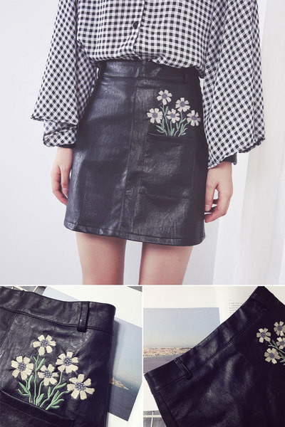 Κομψή φούστα γυναικών σε οικολογικό δέρμα σε μαύρο χρώμα με φυτικά μοτίβα