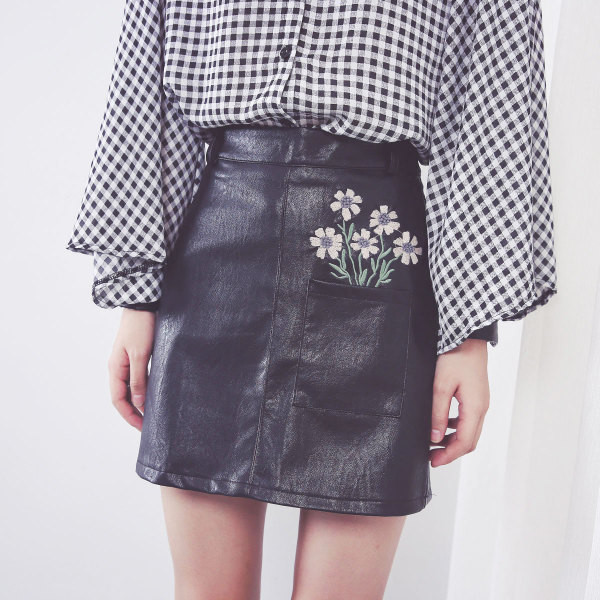 Κομψή φούστα γυναικών σε οικολογικό δέρμα σε μαύρο χρώμα με φυτικά μοτίβα