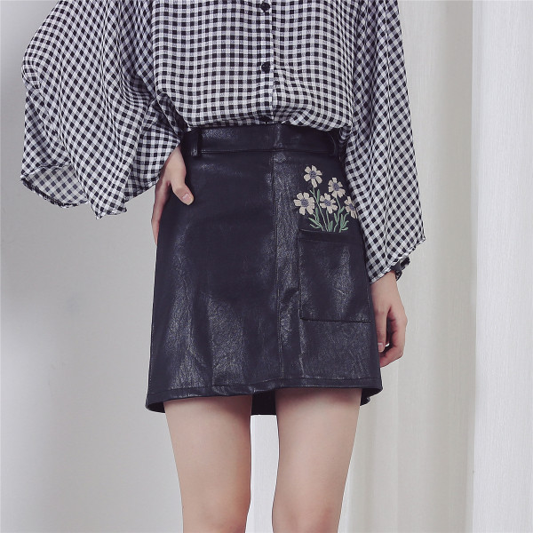 Κομψή φούστα γυναικών σε οικολογικό δέρμα σε μαύρο χρώμα με φυτικά μοτίβα