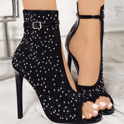 Elegant women`s sandals with high heels and stones in black