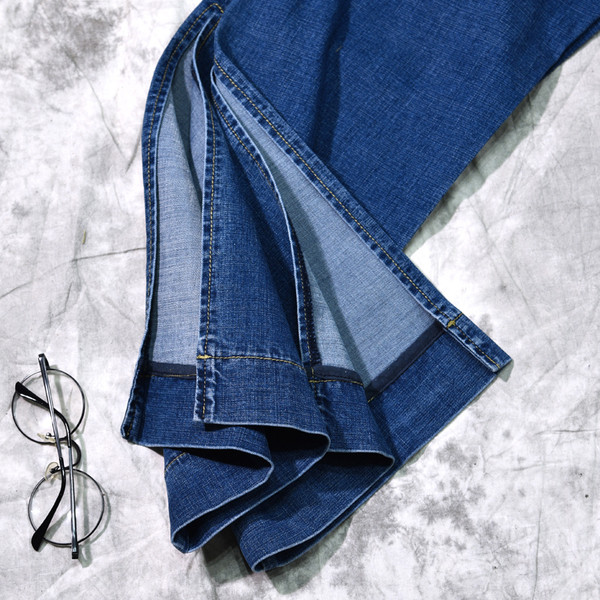 Γυναικεία τζιν σε ένα ευρύ σχέδιο με σχισμή σε σκούρο χρώμα