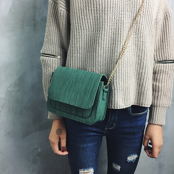 Απλή μικρή γυναικεία τσάντα με μεγάλη λαβή από μέταλλο