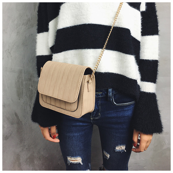 Απλή μικρή γυναικεία τσάντα με μεγάλη λαβή από μέταλλο