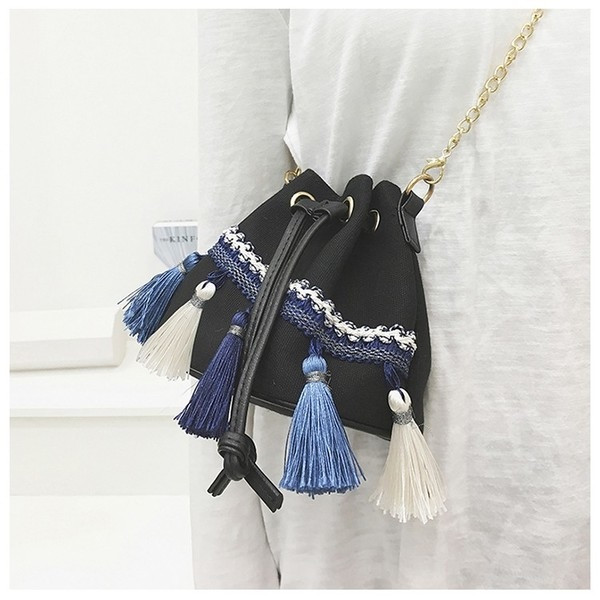 Καθημερινή γυναικεία τσάντα με έγχρωμες φούντες και μεγάλη λαβή από μέταλλο