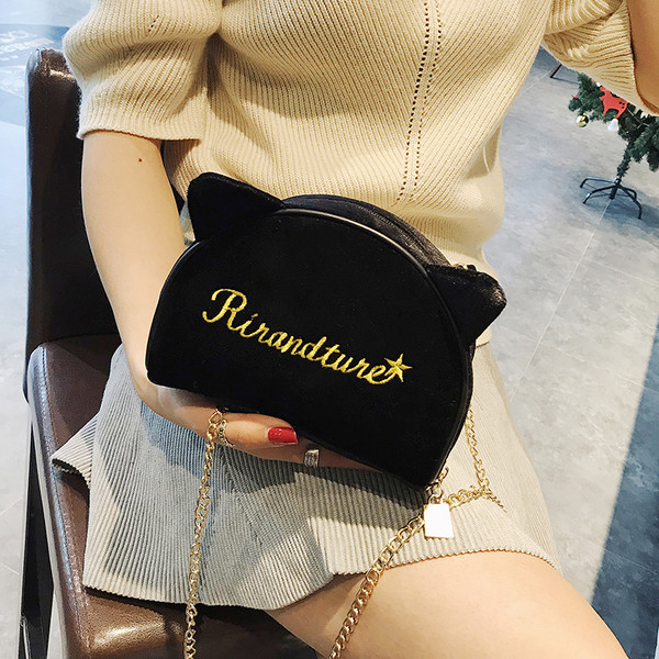 Μια σύγχρονη, μικρή, βελούδινη γυναικεία τσάντα με τα αυτιά 