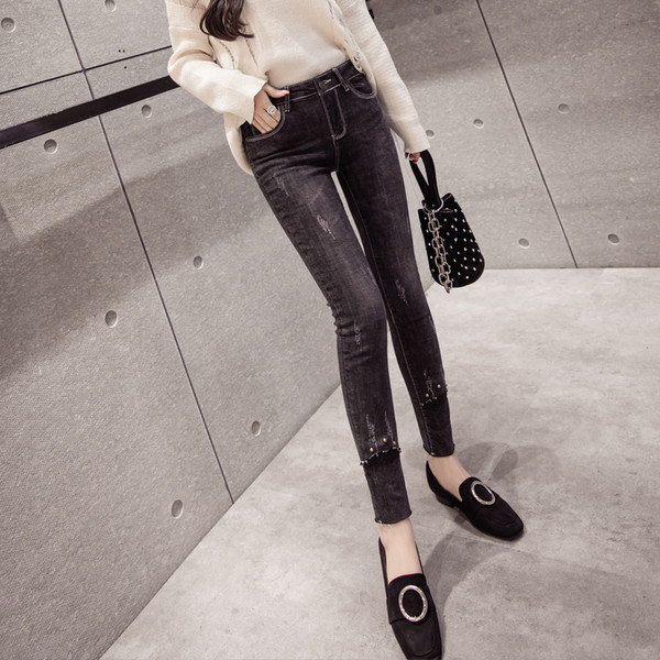Γυναικεία τζιν καθημερινά με διακοσμητικά πριτσίνια σε σκούρο χρώμα