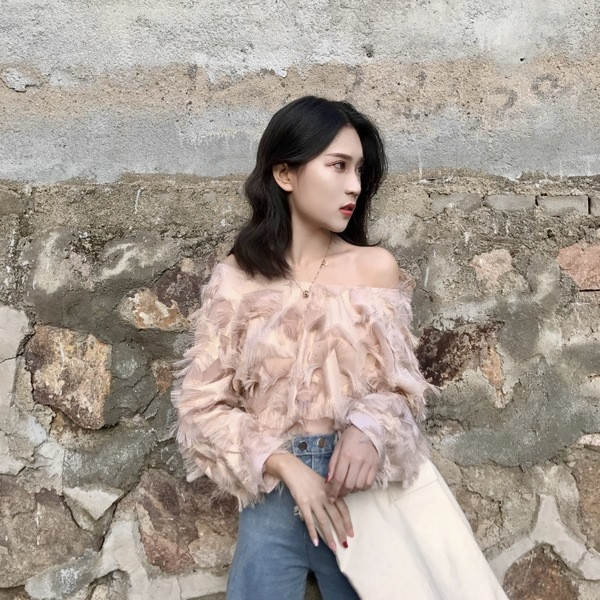 Μια ενδιαφέρουσα γυναικεία μπλούζα με πεσμένους ώμους και κρόσσια