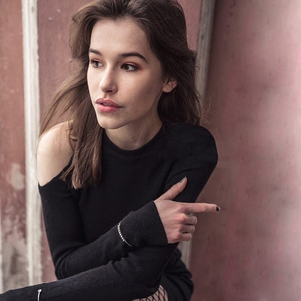 Κομψή γυναικεία μπλούζα σε ένα απλό μοντέλο με γυμνό ώμο σε μαύρο χρώμα