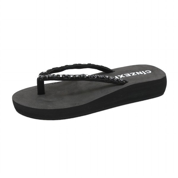 Papuci de dama peste varf pe o platforma cu pietre