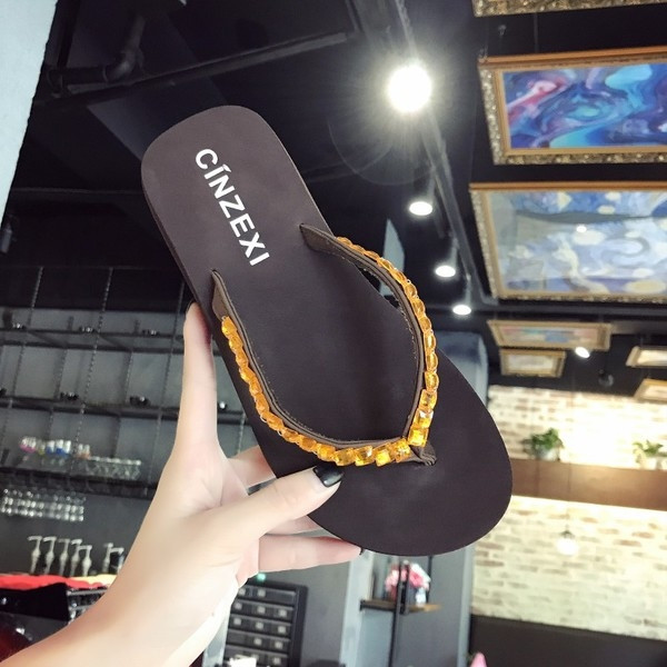 Papuci de dama peste varf pe o platforma cu pietre