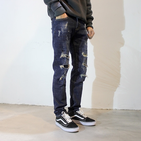 Τα σκούρα μπλε τζιν ανδρικά μεσχισμένα στοιχεία 