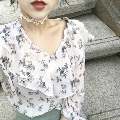 Női éteri blúz virágos motívummal, V-nyakkal és széles, göndör ujjakkal