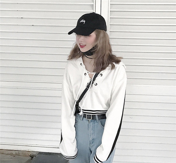 Αθλητική γυναικεία  κοντή μπλούζα με έγχρωμες άκρες και ενδιαφέρουσες διασταυρώσεις σε λευκό χρώμα