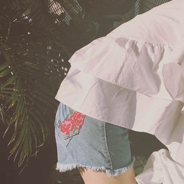 Stílusos női rövid farmer, magas derékkal, világos színű hímzéssel