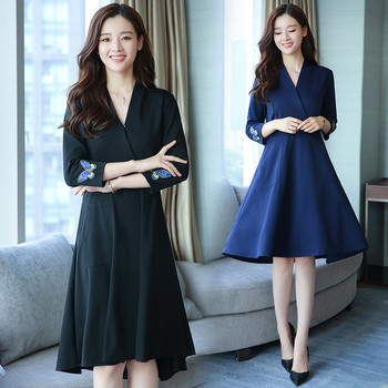 Az elegáns női ruha mély V-nyakkal, gyönyörű hímzéssel és zsebekkel