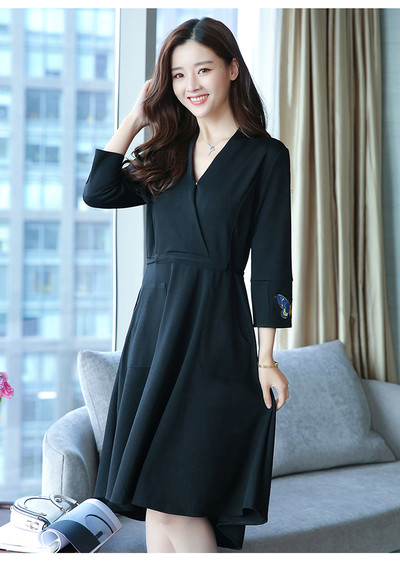 Az elegáns női ruha mély V-nyakkal, gyönyörű hímzéssel és zsebekkel