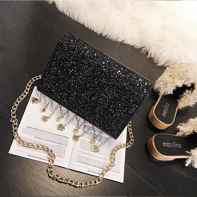 Κομψή γυαλιστερή γυναικεία τσάντα με μεταλλική λαβή και μεταλλικά διακοσμητικά