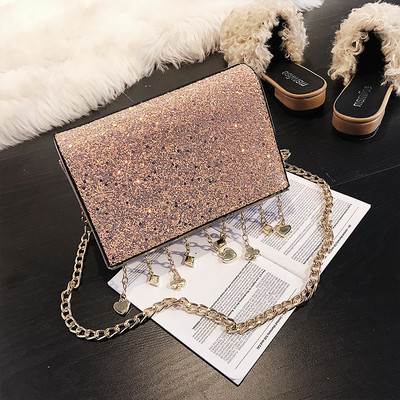 Κομψή γυαλιστερή γυναικεία τσάντα με μεταλλική λαβή και μεταλλικά διακοσμητικά